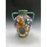 An Italian majolica twin handled painted vase. Height 42cm.