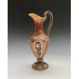 A mid 19th century Bohemian cranberry cut overlay glass ewer with gilt and floral enamel decoration.