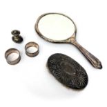 A silver hand mirror, a silver mounted brush, two silver napkin rings and a silver pepper.