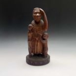 An African carved wood sculpture depicting a woman with three children. Height 39cm.