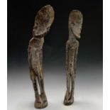 A pair of African carved wood figures, bearing traces of white paint. Tallest height 73cm.