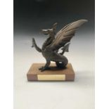 A Peter Hicks bronzed sculpture of a dragon, on rectangular wooden base bearing presentation plaque.