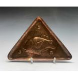 A Newlyn copper pin tray of triangular form, repousee decorated with a fish, stamped 'Newlyn'.