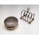 An Edwardian pierced silver potpourri box Chester 1907 2.3oz together with a silver toast rack 2.