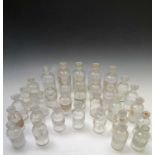 A collection of 36 apothecaries glass jars and stoppers, most with etched labels, some spare