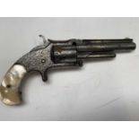 A Smith & Wesson rimfire revolver, serial number 43485, the decoratively engraved steel barrel top