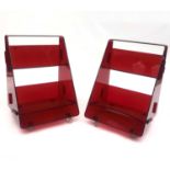 A pair of red acrylic library book caddies by Louis de Bernières, author of Captain Corelli's