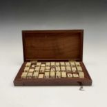 A set of 19th century bone counters, engraved with letters of the alphabet and contained in a