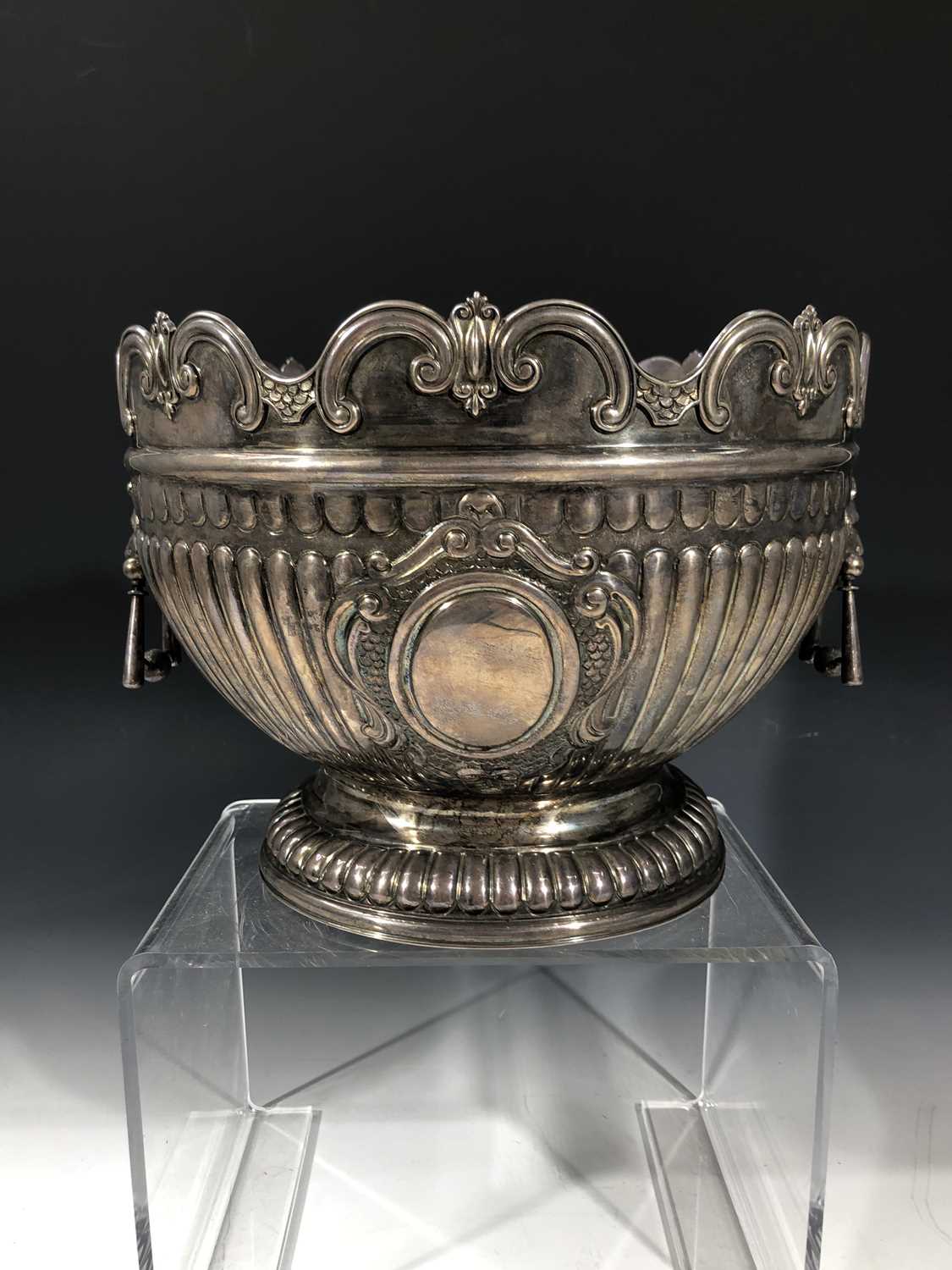 An impressive Scottish retailed silver montieth punch bowl with lions head handles, fluting and a