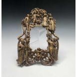 An ornate brass photo frame, cast with dancing couples dressed in historical costume. Height 34cm,