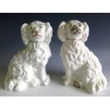 A pair of Victorian Staffordshire curly coated spaniel ornaments. Height 19cm.