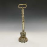 A 19th century brass doorstop, cast as a lion's paw, weighted and with compressed loop handle.