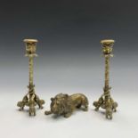 A pair of late 19th century brass candlesticks, the nozzles cast with horned animal heads, vine cast