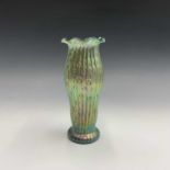 A Loetz type iridescent green glass vase, circa 1910, with crinoline rim, the baluster body with