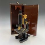 A black lacquered brass microscope, by Belcher & Mason, circa 1920, contained in a mahogany case,