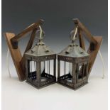 A pair of square section brass lanterns with oak wall brackets. Height of lanterns 27cm, overall