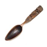 A 19th century continenal carved fruitwood spoon, the handle carved with a fruiting vine and dated