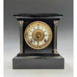 A late 19th century American 8 day cast iron cased mantel clock with twin pressed brass column