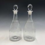 A pair of Regency glass decanters, with flattened teardrop stoppers and foliate swag engraved