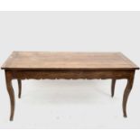 A French fruitwood kitchen table, with one end drawer opposed by a later extension leaf, on
