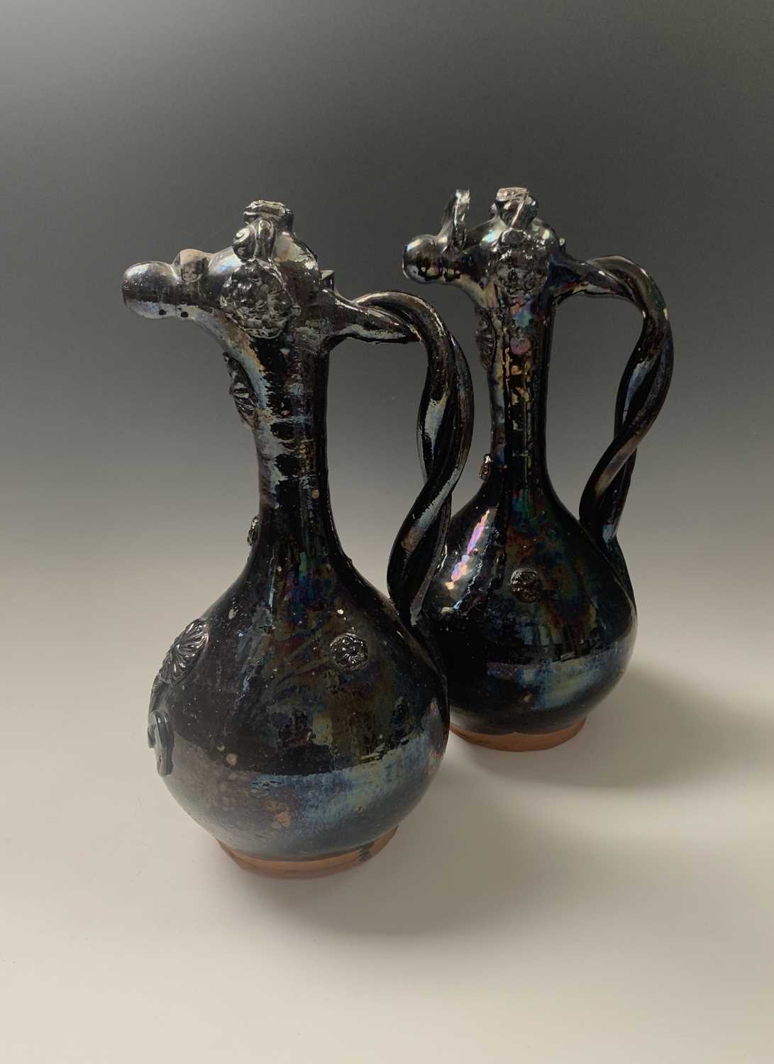 A near pair of Turkish black lustre glazed pottery ewers, 19th century, Ottoman Turkey, each with