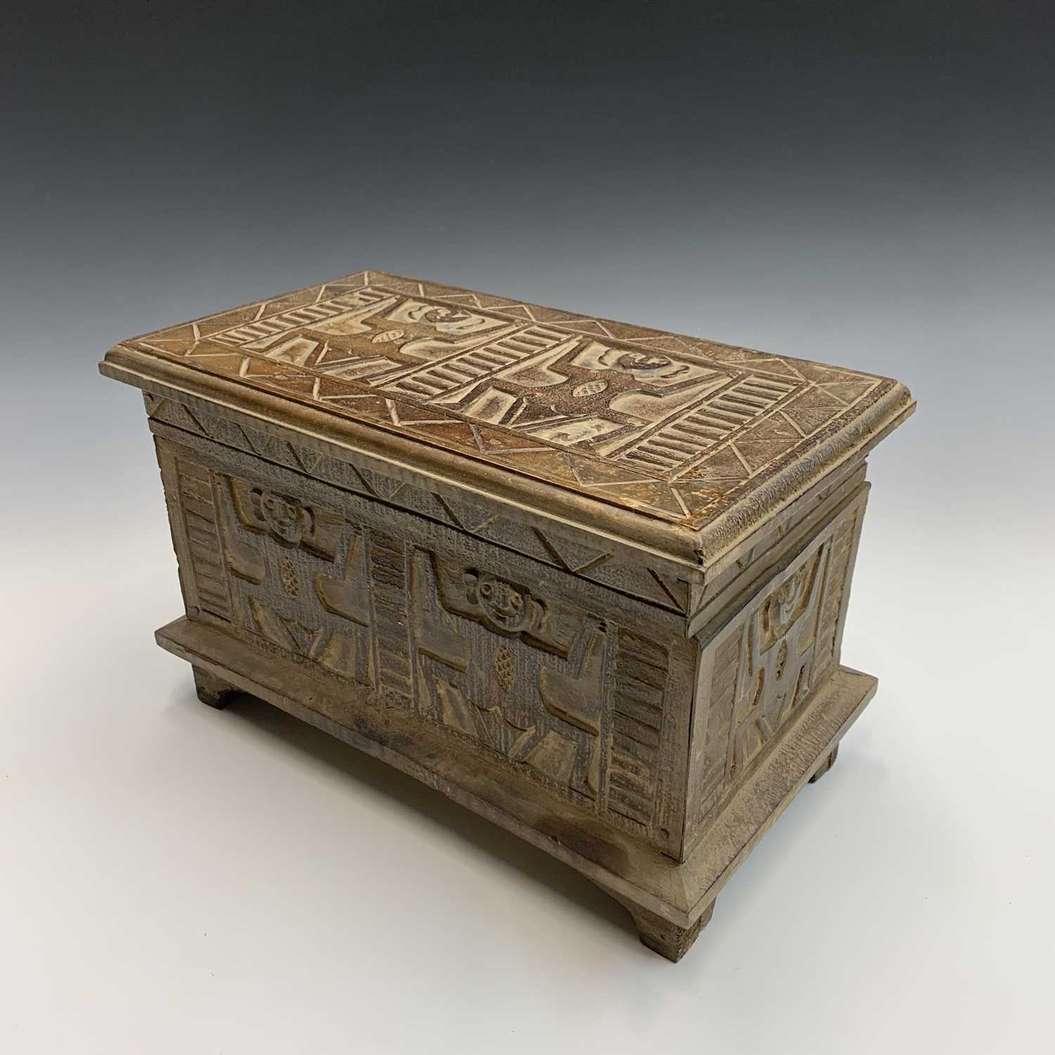 An African carved wood box with figural and geometric decoration. Height 22cm, width 35cm, depth