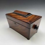 An early Victorian mahogany tea caddy of sarcophgus form, on bun feet, with fitted interior and