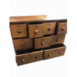 A teak bank of drawers, circa 1800, with an arrangement of nine drawers and turned wooden knobs,