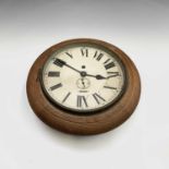 A small oak cased circular station wall clock, early 20th century, the English movement with