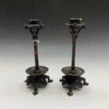 A pair of bronze candlesticks, early 20th century, each with column supports, dished bases and