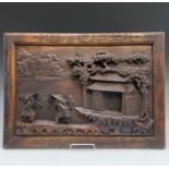 A Chinese hardwood panel, carved in high relief with two figures on a bridge beside a building,