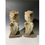 A pair of French terracotta seated lions with shields. Height 45cm.
