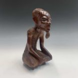 An African carved hardwood figure of a seated Gambian elder. Height 29cm