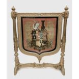 A Victorian gilt painted shield shape firescreen, the wool and beadwork panel featuring an