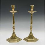 A pair of tall continental brass candlesticks, probably early 19th century, with hexagonal drip pans