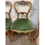 A set of four Victorian walnut dining chairs, each with a shaped and carved horizontal splat,