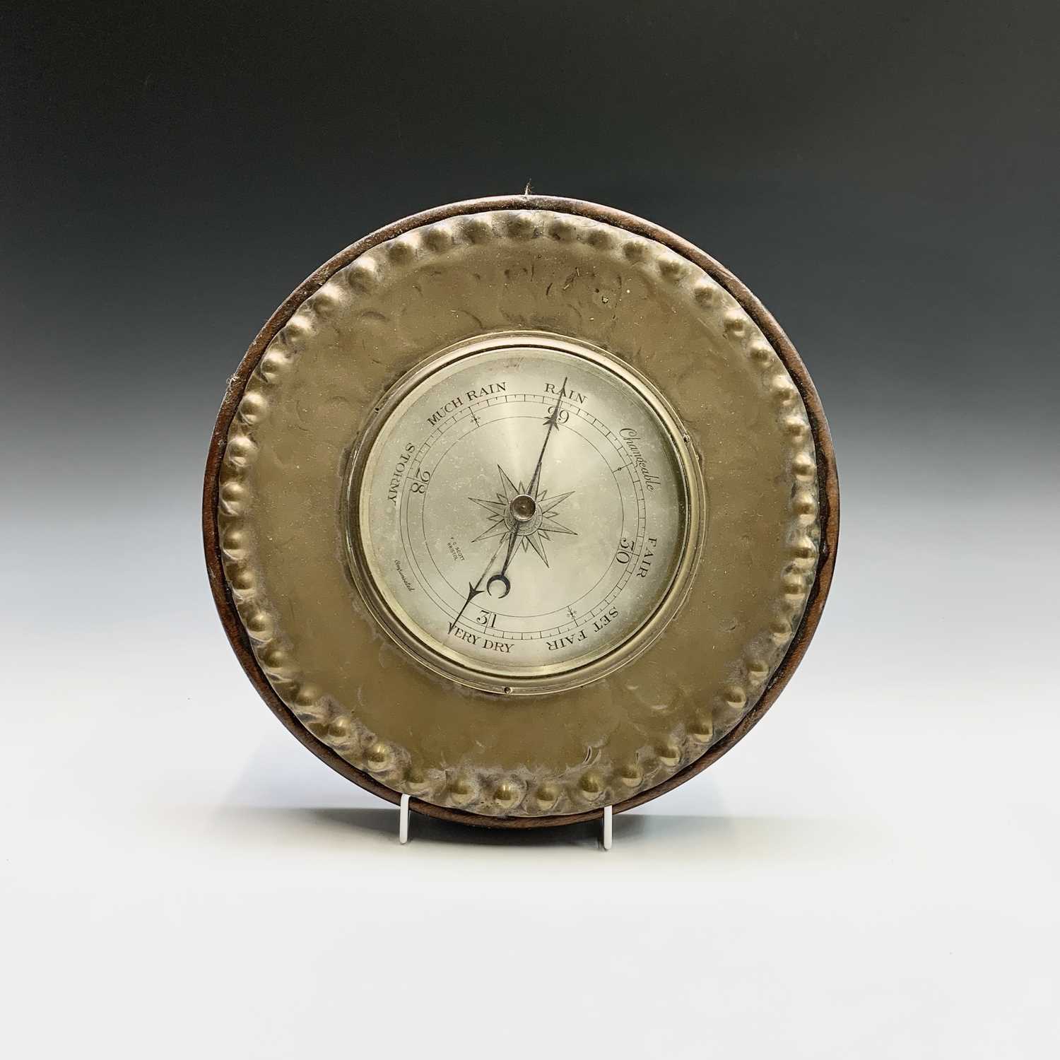An aneroid barometer retailed by Scott, Bristol, in a brass surround and two other barometers (3).