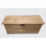 A pine blanket box, 18th century, on shaped plank end supports, height 61cm, width 124cm, depth