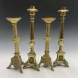 A pair of late 19th century Continental brass altar candlesticks, with fluted columns on mask cast