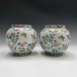 A pair of Japanese porcelain jardinieres, with floral and butterfly painted decoration, height