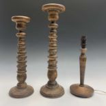 Two turned wood acanthus design candle stands, heights 49.5cm and 43cm, together with a turned