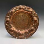 An Arts and Crafts period copper charger, the border repousse decorated with persimmon fruit, the