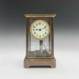 A German 400 day brass four glass torsion clock, the cream circular dial with gilt brass mask and