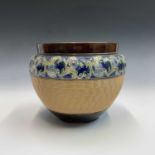A Royal Doulton stoneware jardiniere, with basket weave moulded decoration below a floral border.