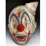 A clown head painted on wood. 86cm x 60cm (irregular).