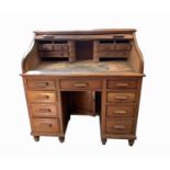 An oak roll top desk, early 20th century, the tambour shutter enclosing drawers, compartments and