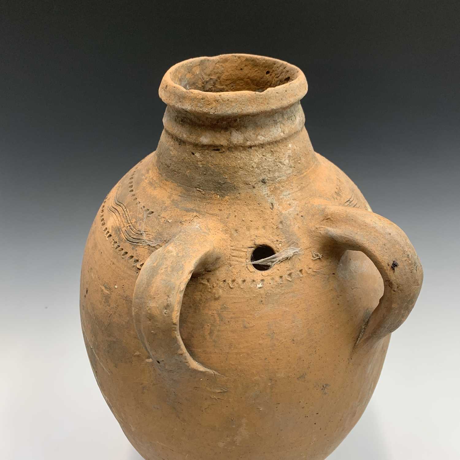 A terracotta vessel with twin handles, incised and impressed banded decoration. Height 55cm. - Image 2 of 4