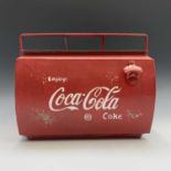 A red painted tin cool box with handle, with raised lettering 'Coca Cola'. Width 45cm.