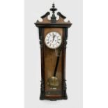 A late 19th century walnut and ebonised Vienna type wall clock, with white enamel dial and weight