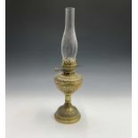 A late 19th/early 20th century brass oil lamp with repousse decoration. Height 53cm overall.